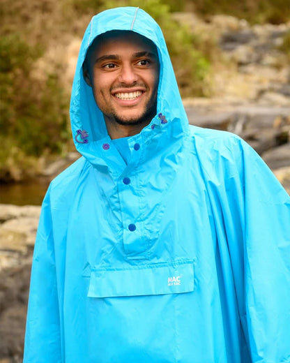 Neon Blue coloured Mac In A Sac Waterproof Poncho on a blurry background 