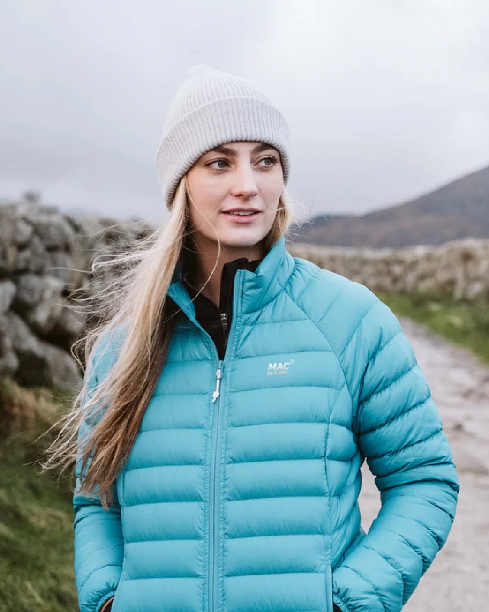 Soft Teal coloured Mac In A Sac Womens Synergy Jacket on blurry mountain background 