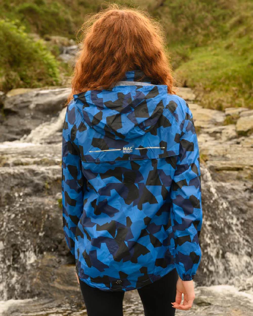 Blue Camo coloured Mac In A Sac Packable Origin Camo Waterproof Jacket on blurry background 