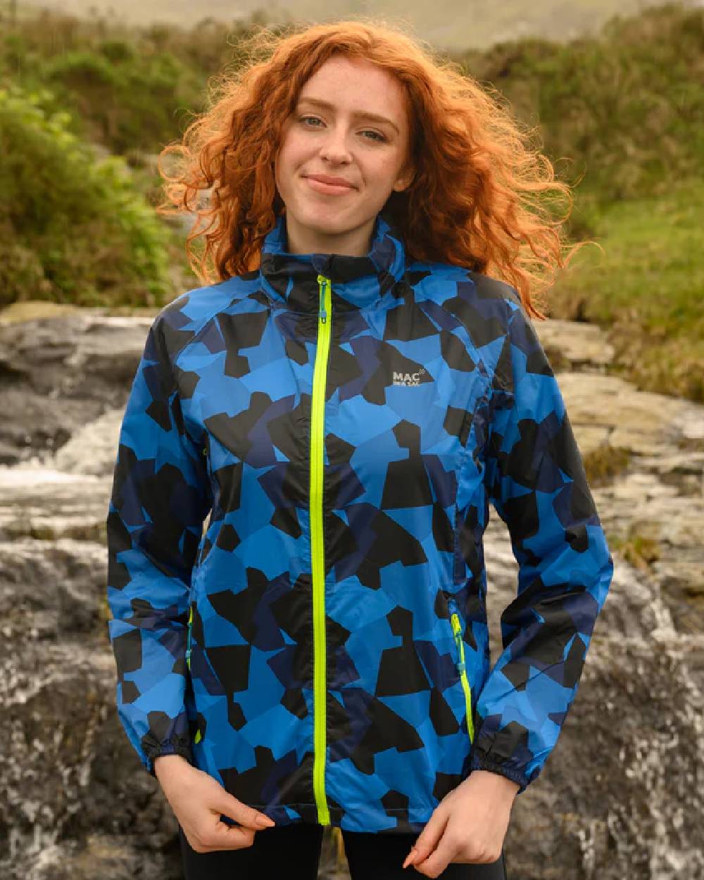 Blue Camo coloured Mac In A Sac Packable Origin Camo Waterproof Jacket on blurry background 