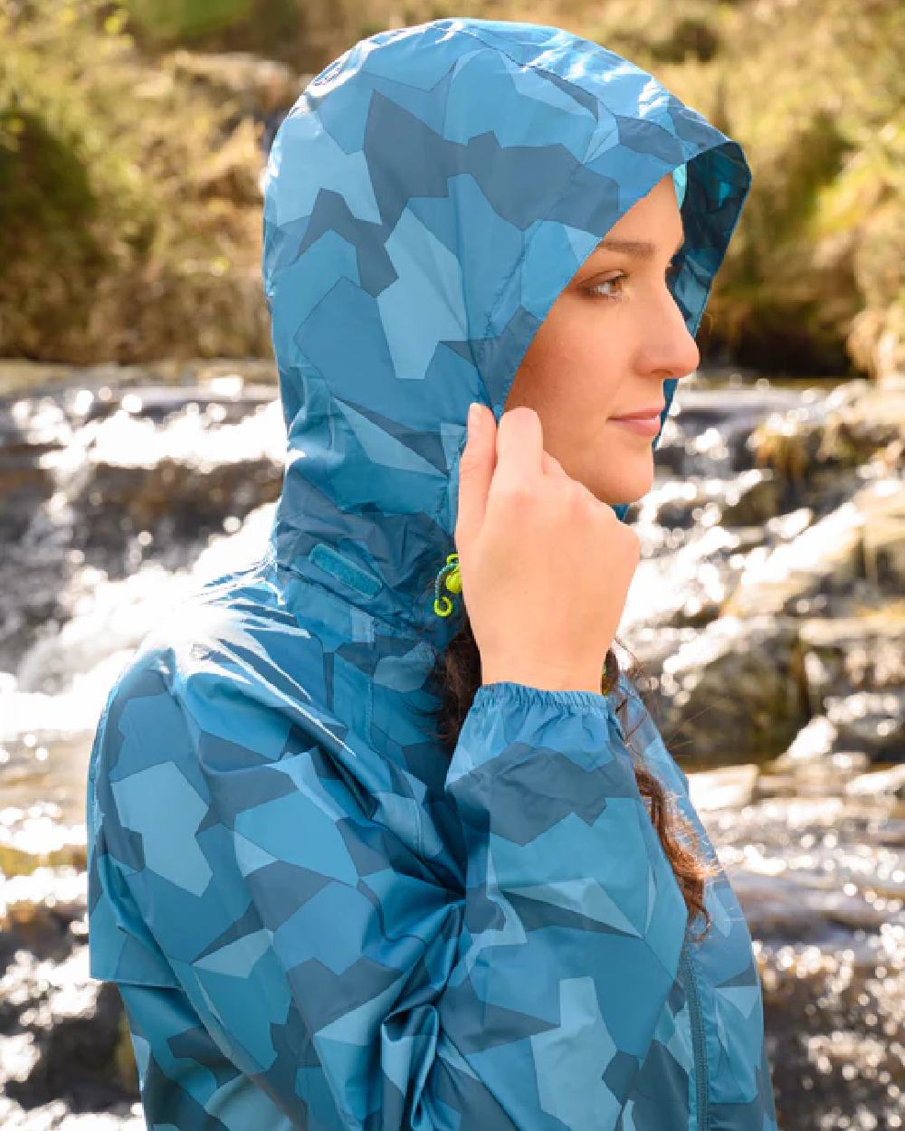 Teal Camo coloured Mac In A Sac Packable Origin Camo Waterproof Jacket on blurry background 