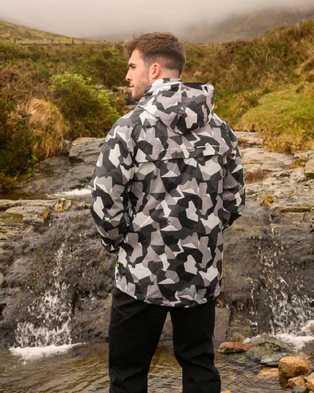 White Camo coloured Mac In A Sac Packable Origin Camo Waterproof Jacket on blurry background 