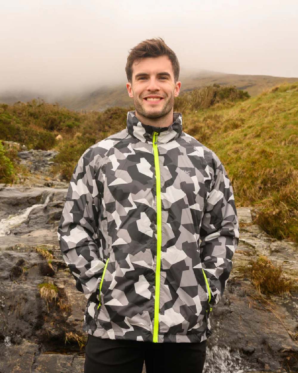 White Camo coloured Mac In A Sac Packable Origin Camo Waterproof Jacket on blurry background 