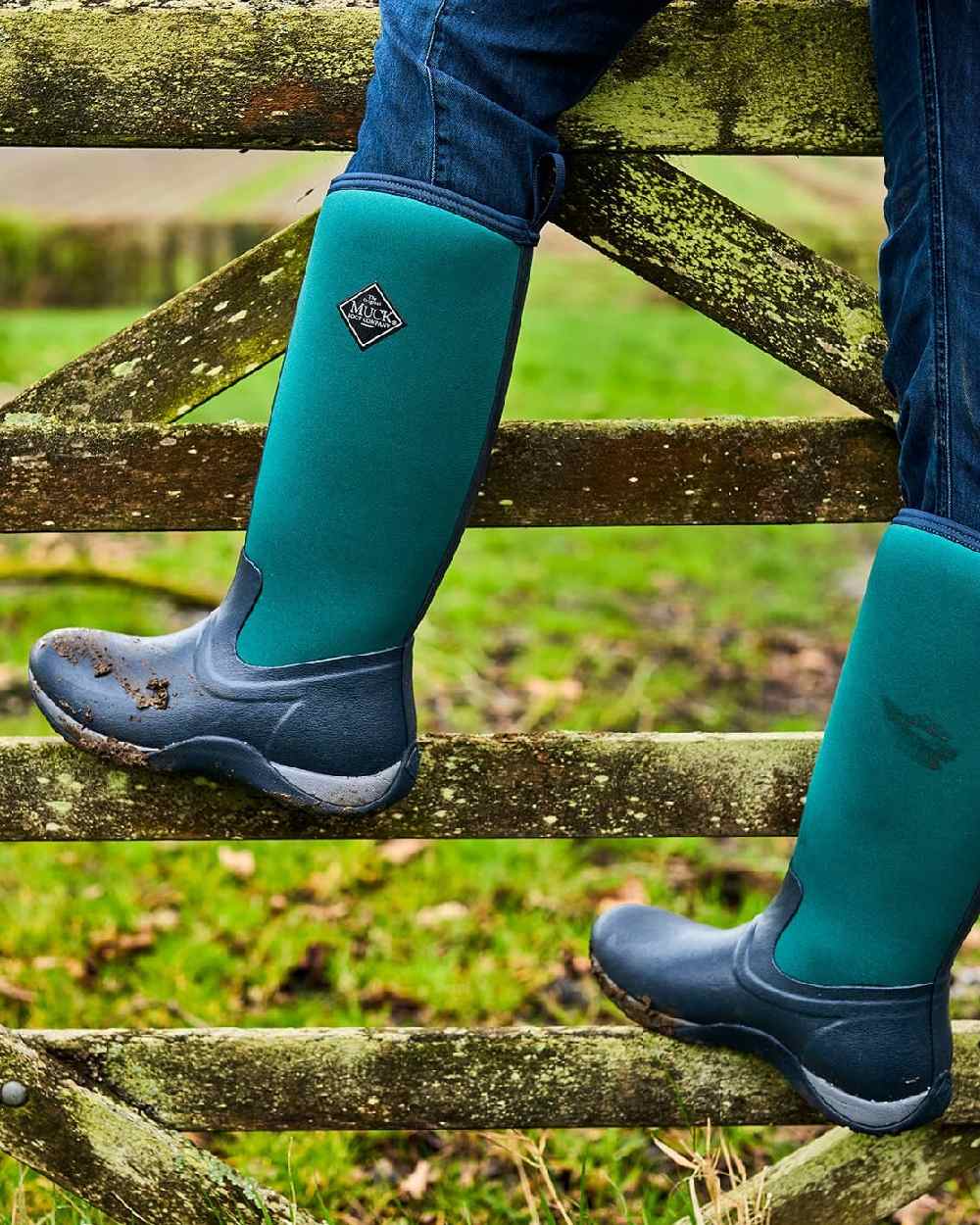 Navy Spruce Coloured Muck Boots Womens Arctic Adventure Tall Boots on blurry background 