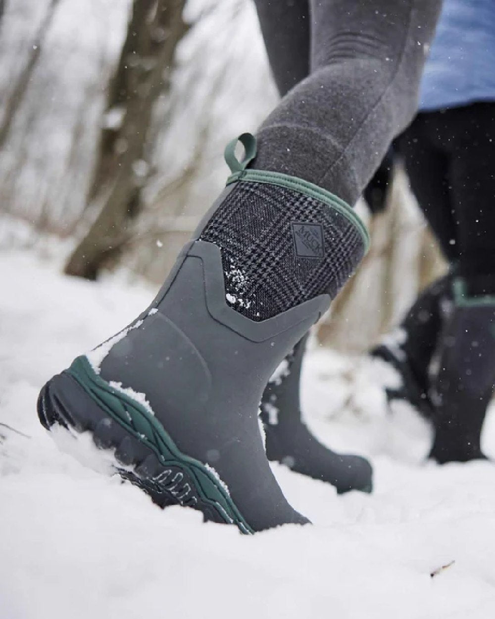 Grey Plaid Print Coloured Muck Boots Womens Arctic Sport II Mid Wellingtons on snow background 