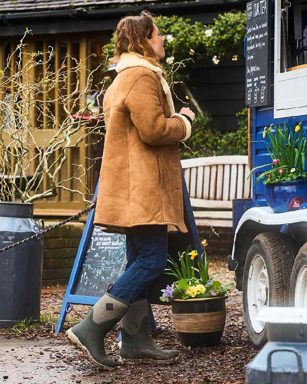 Olive Herringbone Print Coloured Muck Boots Womens Arctic Sport II Mid Wellingtons on countryside background 