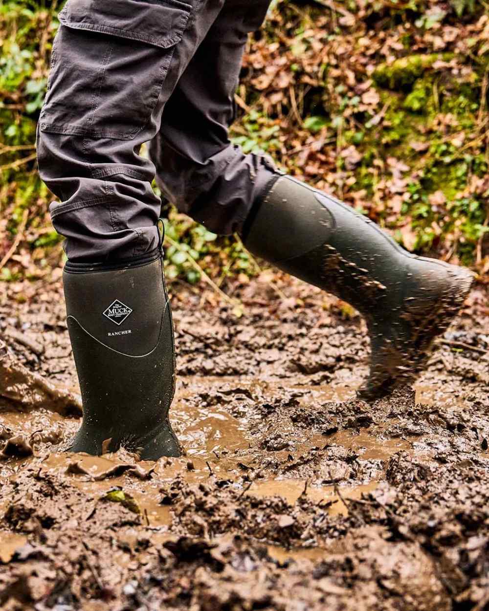 Olive coloured Muck Boots Mens Muck Rancher Tall Boots on muddy background 