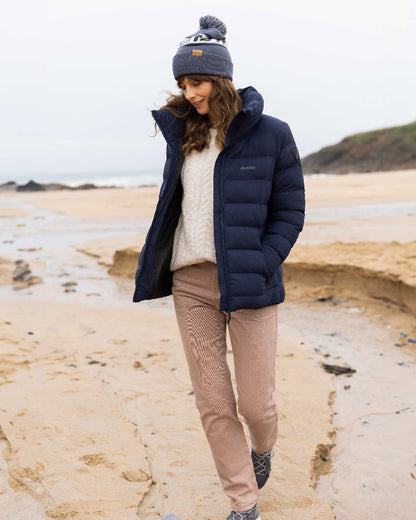 Ombre Blue Coloured Musto Bobble Hat on beach background 