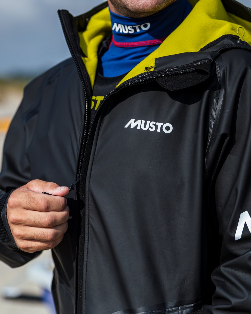 Black coloured Musto Champ Aqua Hoodie Jacket on blurry background 