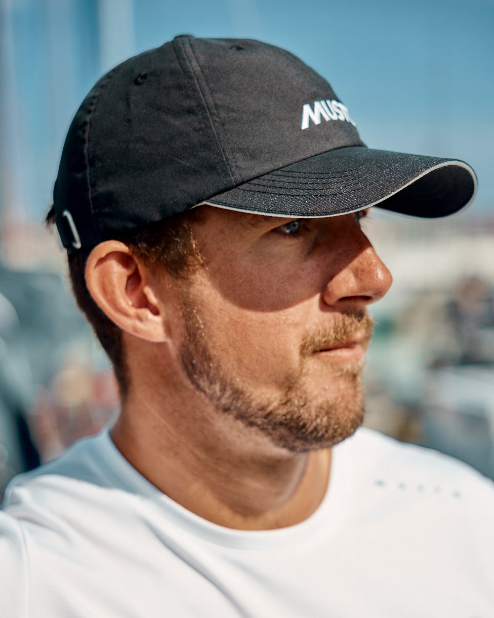 Black coloured Musto Essential Fast Dry Crew Cap on outdoor background 