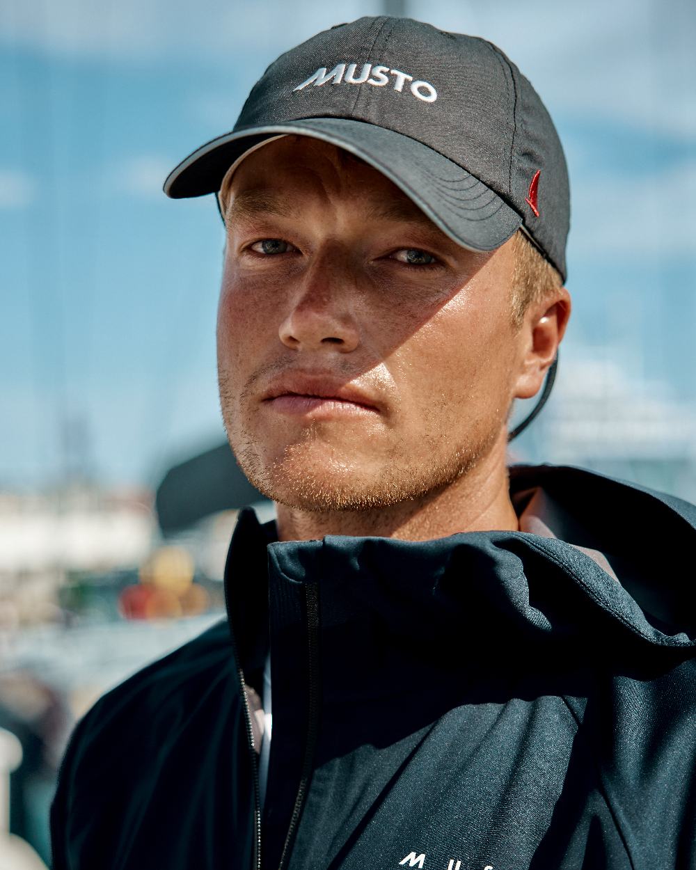 Black coloured Musto Essential Fast Dry Crew Cap on outdoor background 
