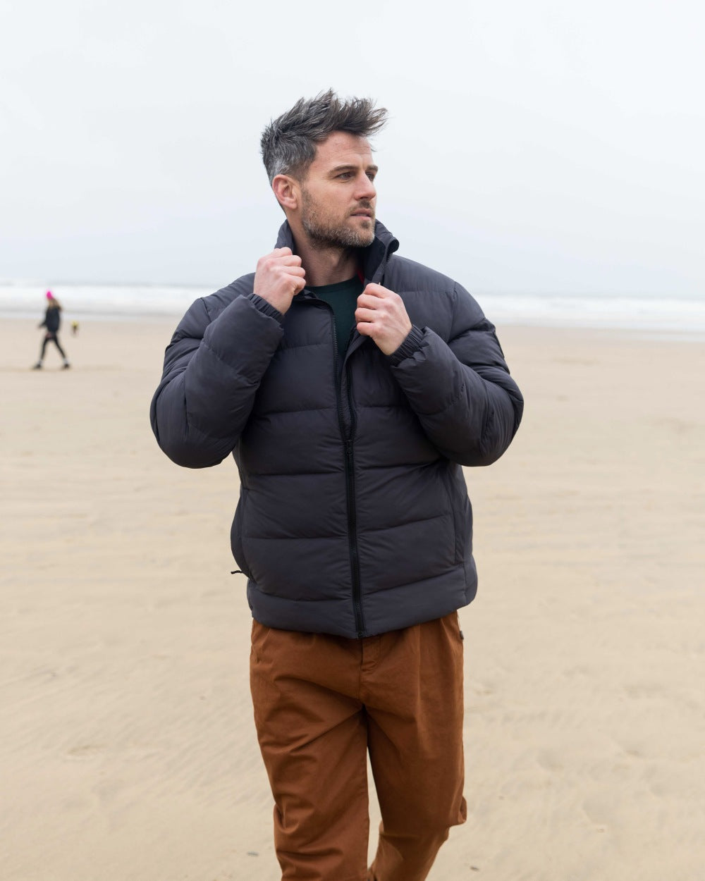 Carbon Coloured Musto Mens Active Puffer Jacket on beach background 