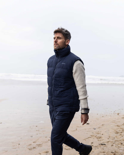 Navy Coloured Musto Mens Active Puffer Vest on beach background 