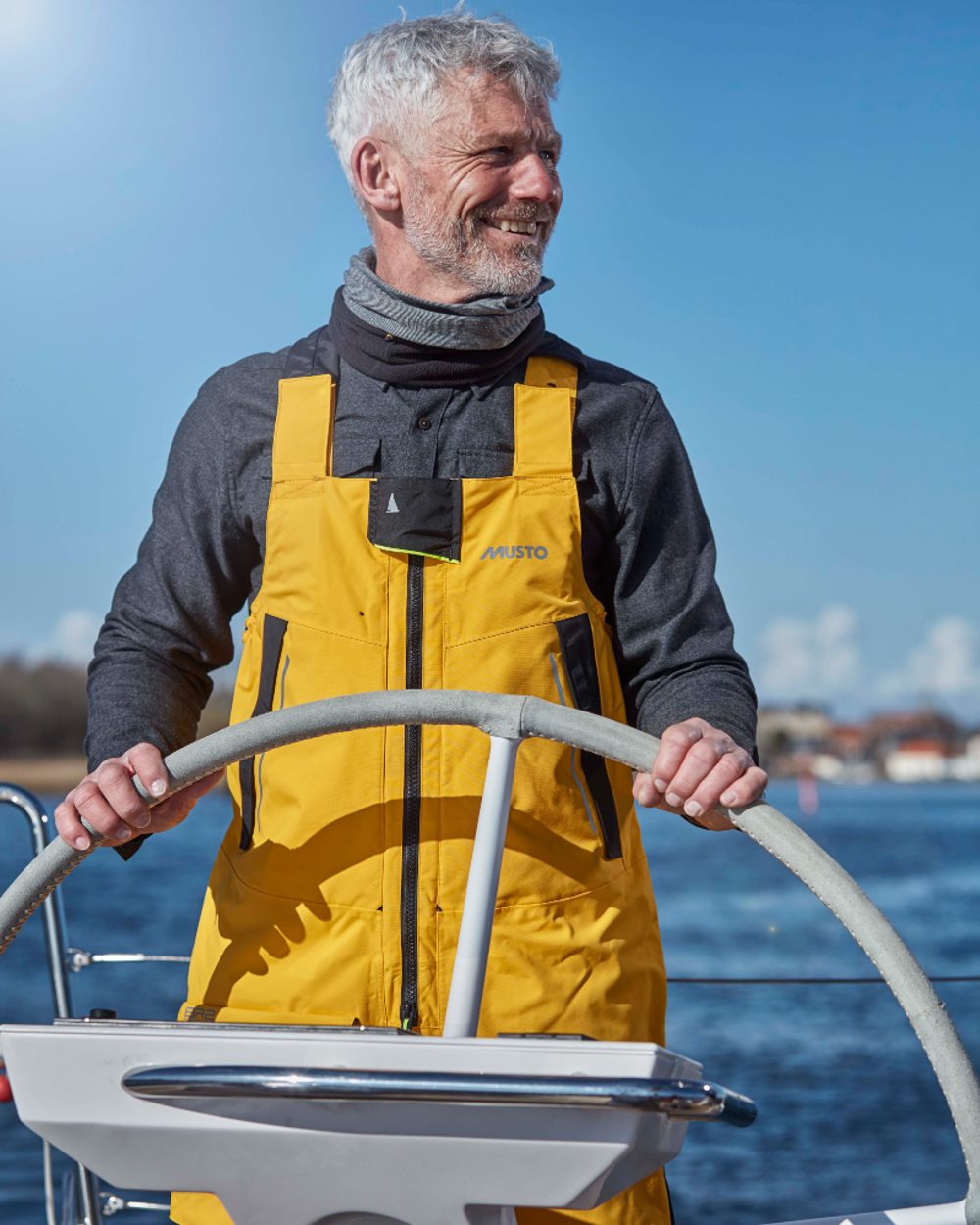 Gold coloured Musto Mens Br2 Offshore Trouser 2.0 on blurry background 