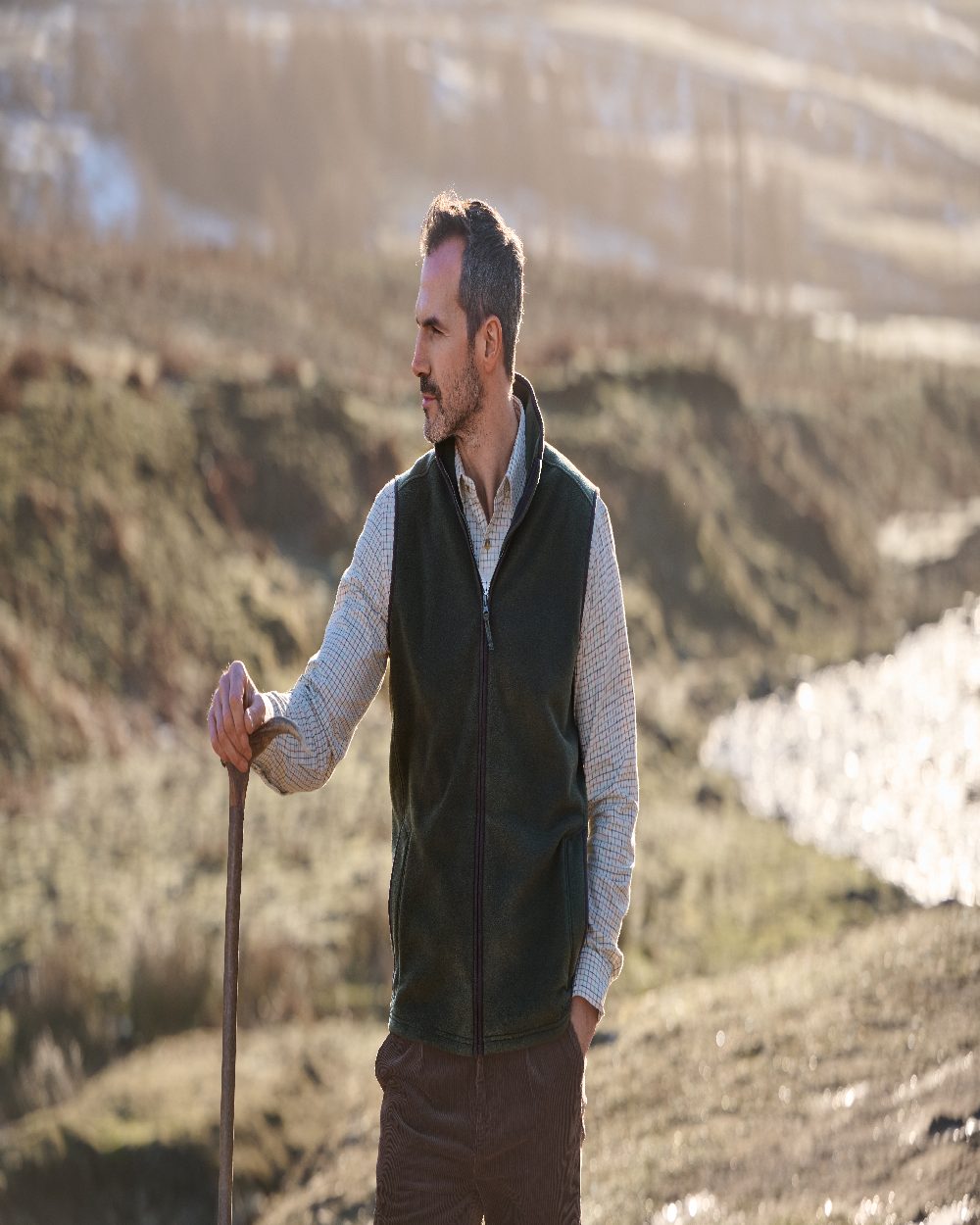 Deep Green Coloured Musto Mens Fenland 200 Polartec Vest on Mountain Background 