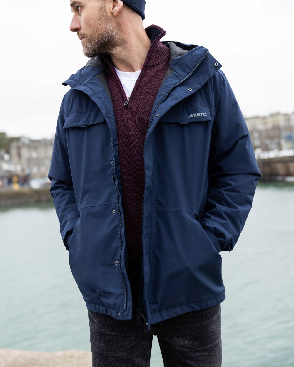 Navy Coloured Musto Mens Insulated Rain Jacket on lake background 