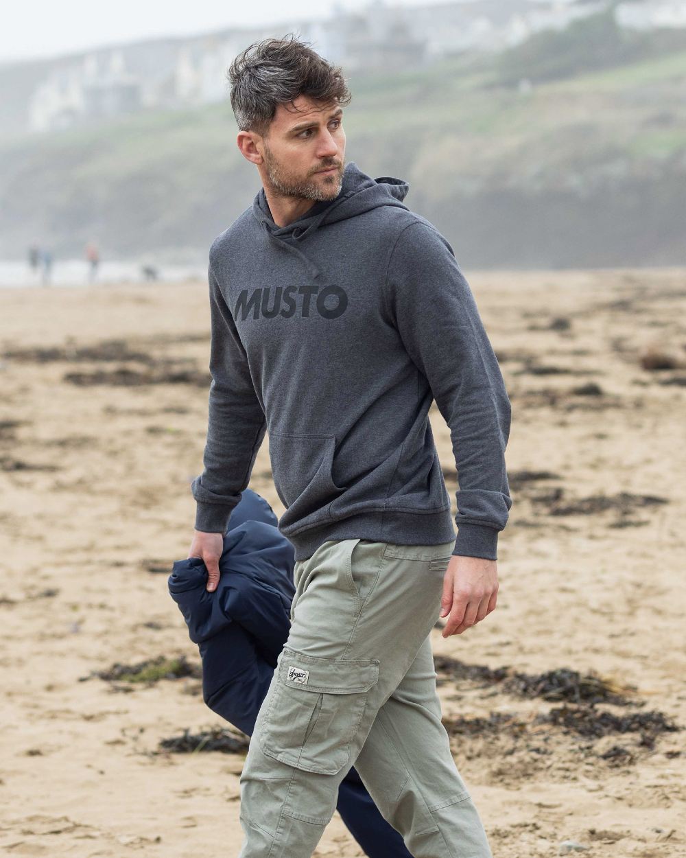 Dark Grey Marl coloured Musto Mens Logo Hoodie on blurry mountain background 