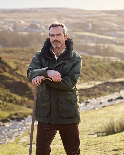 Deep Green Coloured Musto Mens Westmoor Waterproof Jacket on Outdoor Moorland Background 