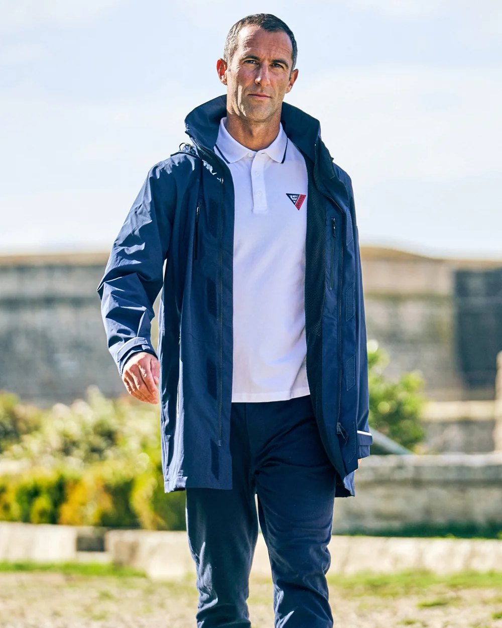 Navy coloured Musto Sardinia Long Rain Jacket on sky background 