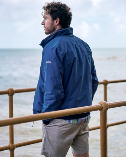 Marine Blue coloured Musto Snug Blouson Jacket 2.0 on blurry background 