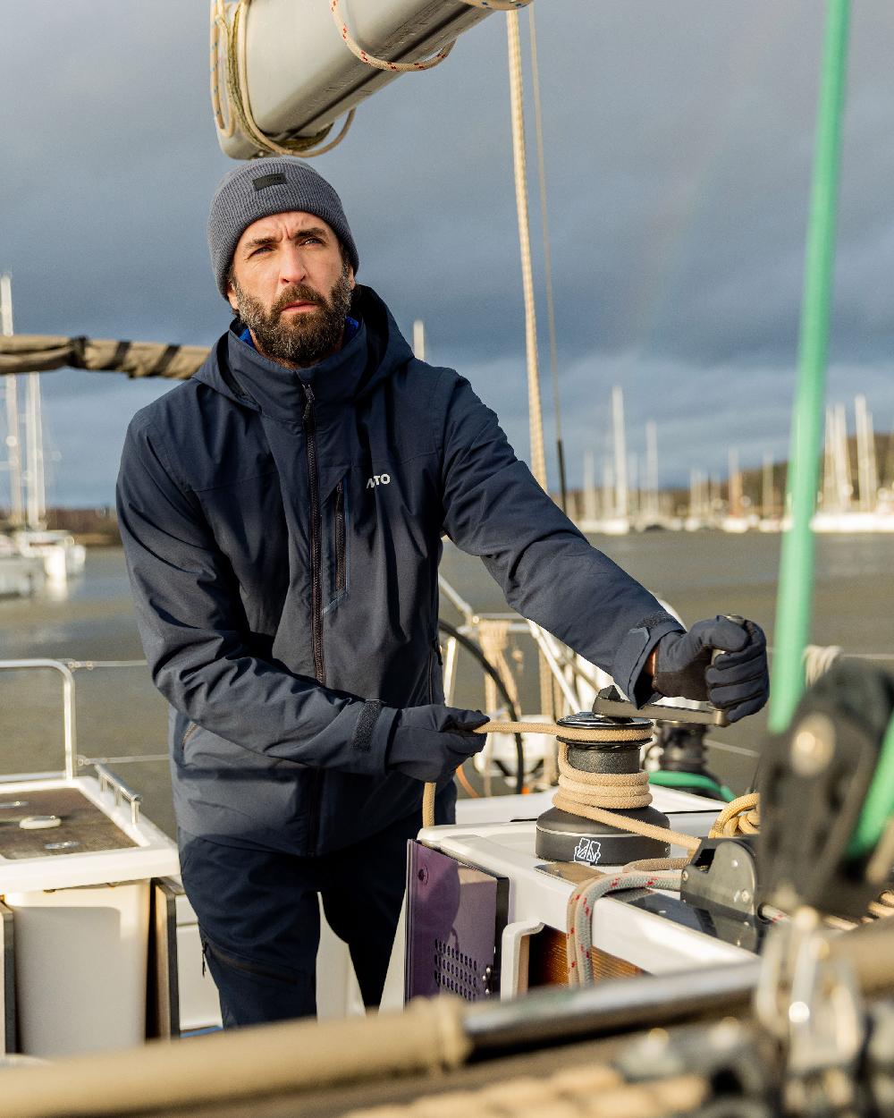 Navy Coloured Musto Snug Gloves on sea background 