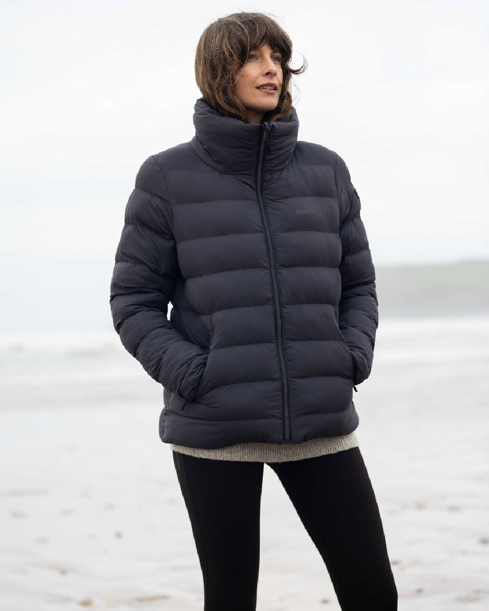 Carbon Coloured Musto Womens Active Puffer Jacket on blurry background 