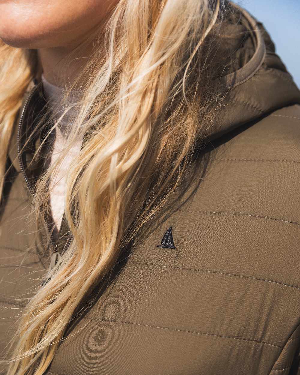 Crocodile Coloured Musto Womens Original Lite Puffer Coat on sea background 