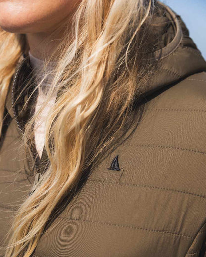 Crocodile Coloured Musto Womens Original Lite Puffer Coat on sea background 