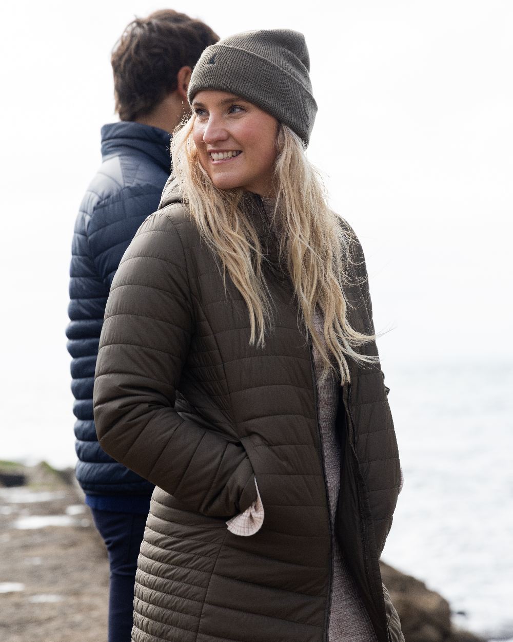 Crocodile Coloured Musto Womens Original Lite Puffer Coat on sea background 