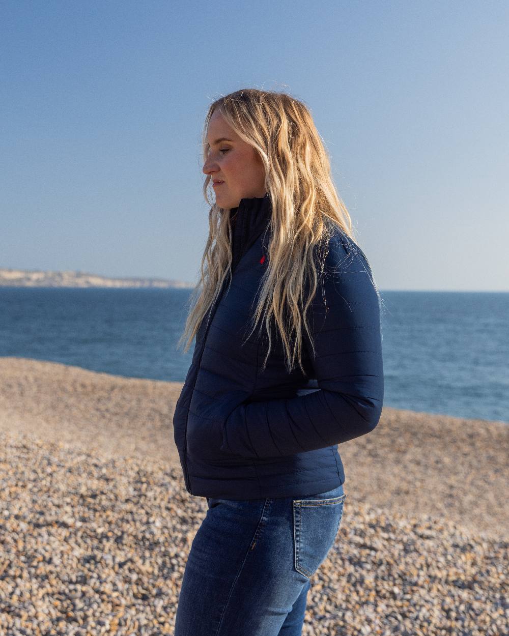 Navy Coloured Musto Womens Original Lite Puffer Jacket on beach background 