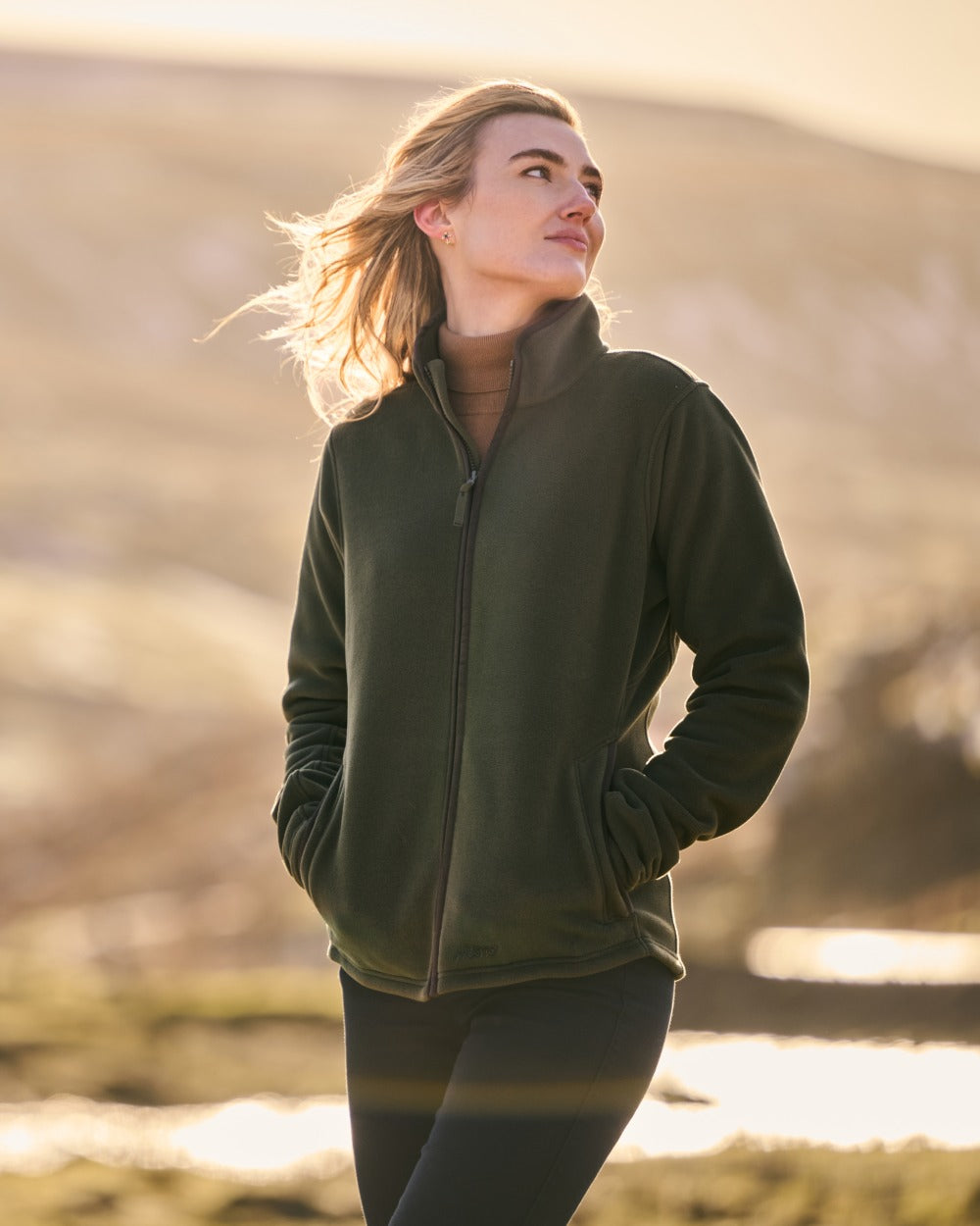 Deep Green Coloured Musto Womens Fenland 200 Polartec Jacket on Mountain side Background 