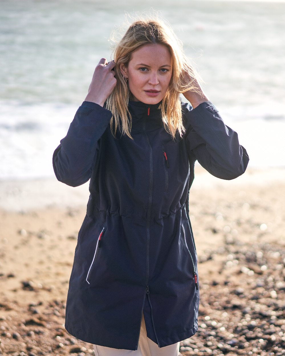 Navy coloured Musto Ladies Sardinia Rain Jacket on Beach background 