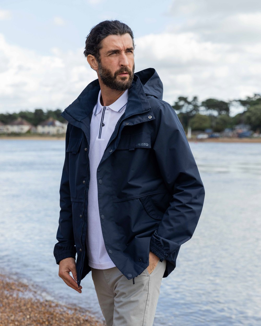 Navy Coloured Musto Mens Classic Shore Waterproof Jacket On A Beach Background 