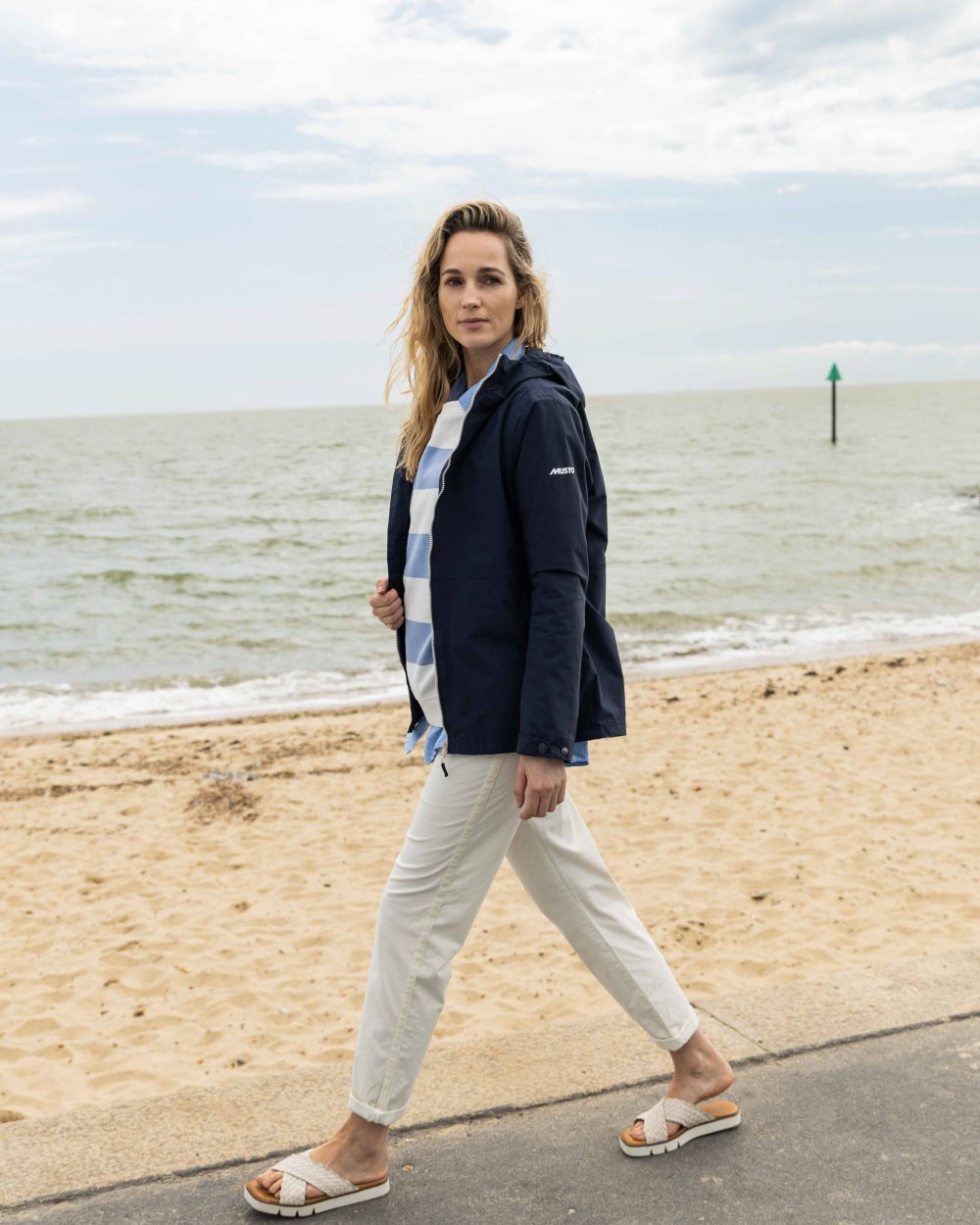 Navy Coloured Musto Womens Marina Rain Jacket On A Beach Background 