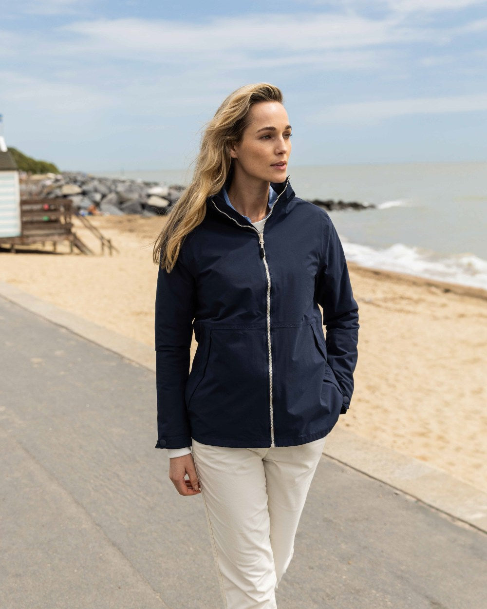 Navy Coloured Musto Womens Marina Rain Jacket On A Beach Background 