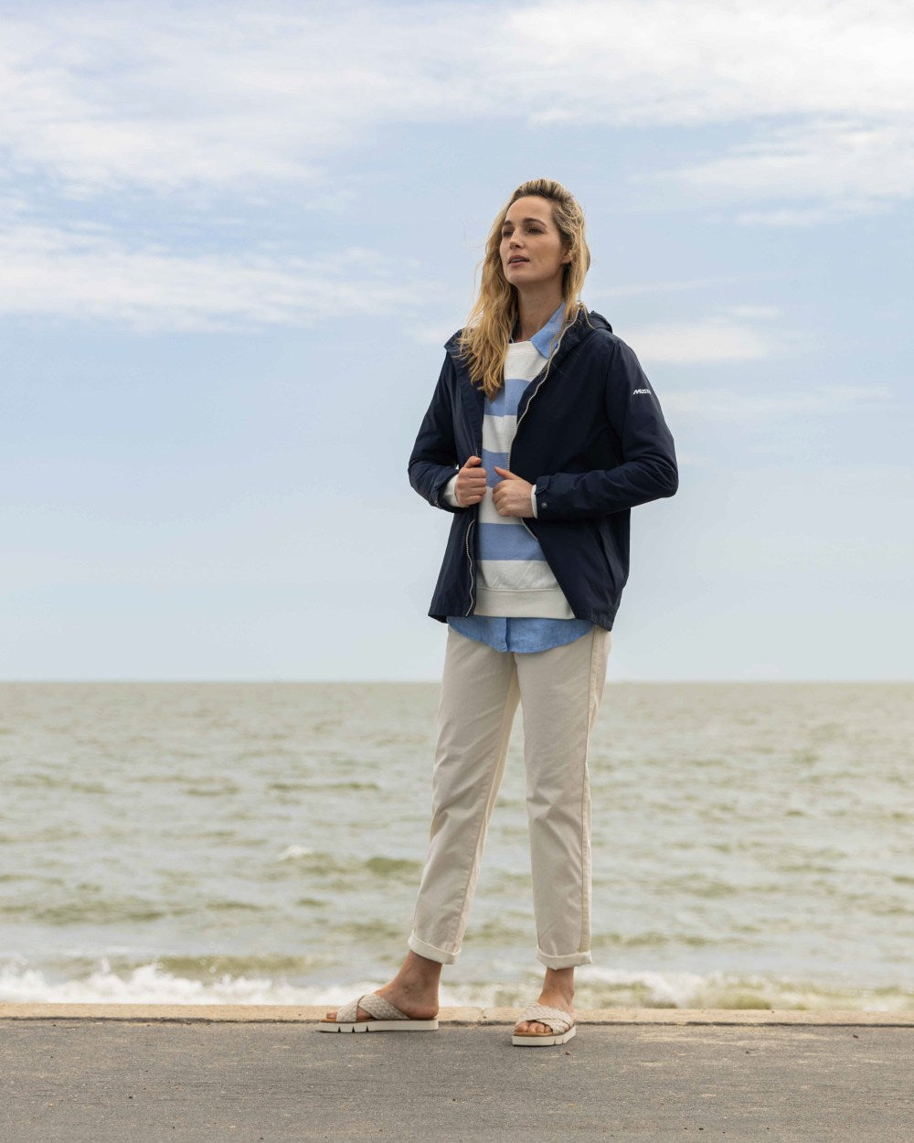 Navy Coloured Musto Womens Marina Rain Jacket On A Beach Background 