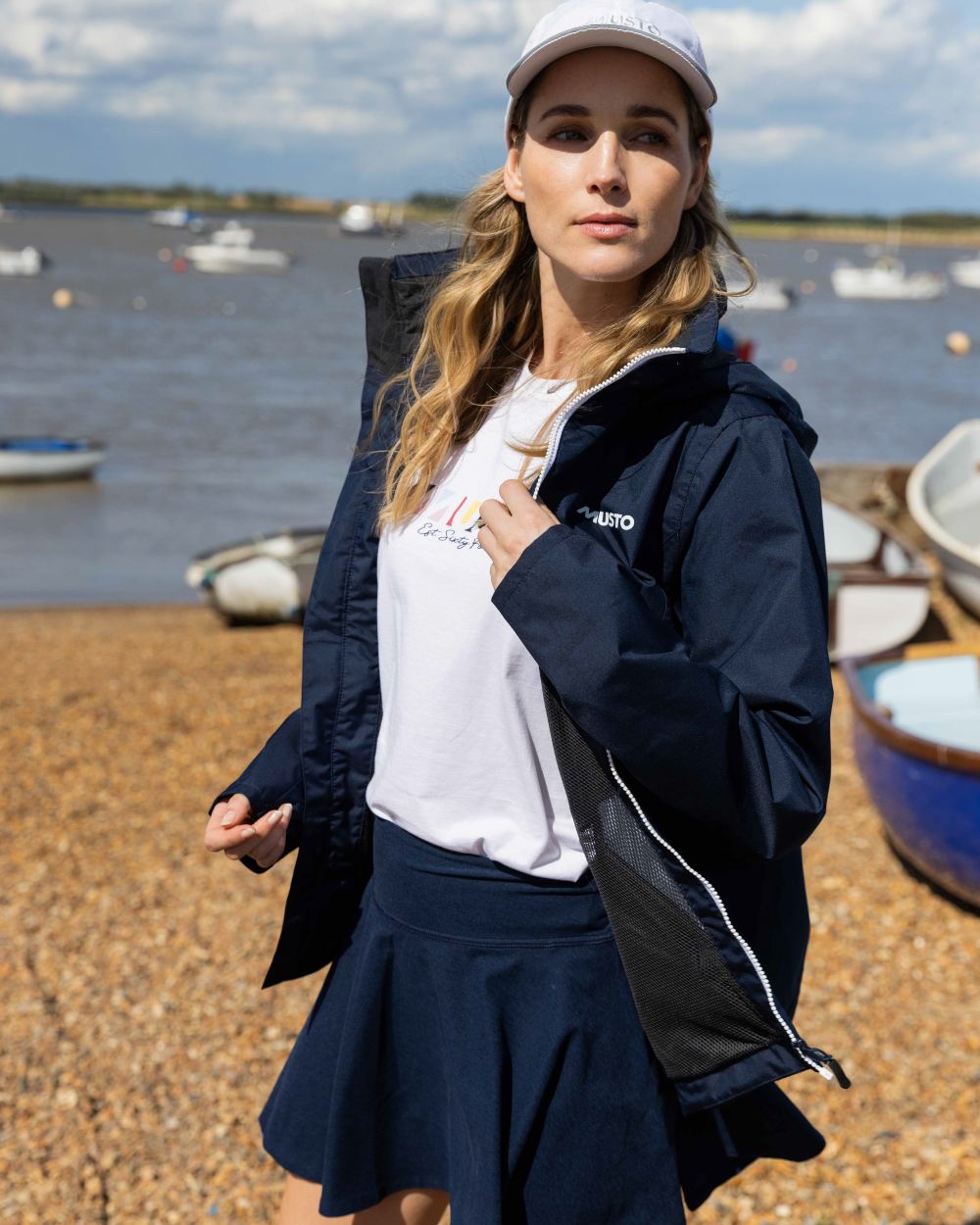 Navy Coloured Musto Womens Nautic Rain Jacket On A Beach Background 