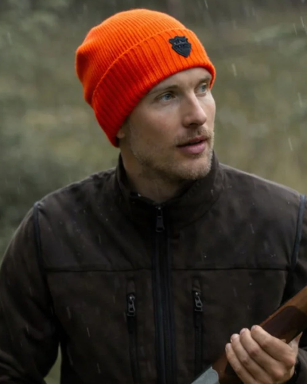 Orange coloured Northern Hunting Buk Windstop Beanie on forest background 