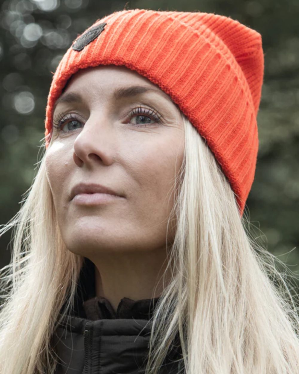 Orange coloured Northern Hunting Buk Windstop Beanie on forest background 
