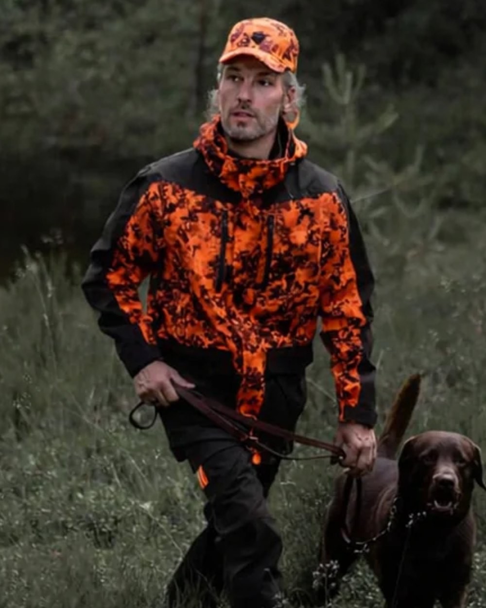Dark Green Orange Blaze coloured Northern Hunting Mens Falkor Aks Waterproof Hunting Jacket on forest background 