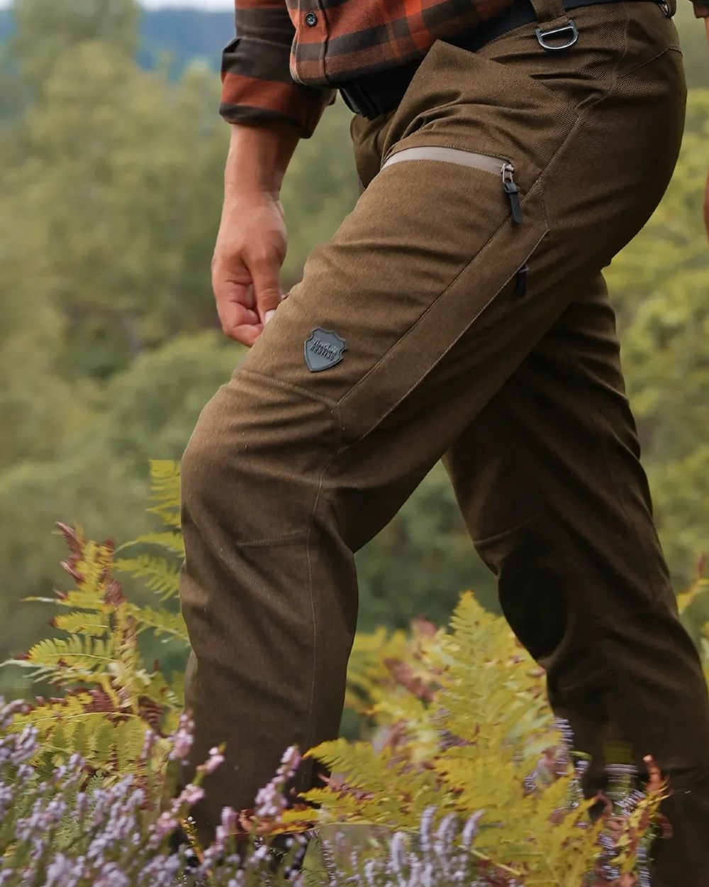 Green coloured Northern Hunting Mens Gunnar Alp Waterproof Addventex Hunting Trousers on forest background 