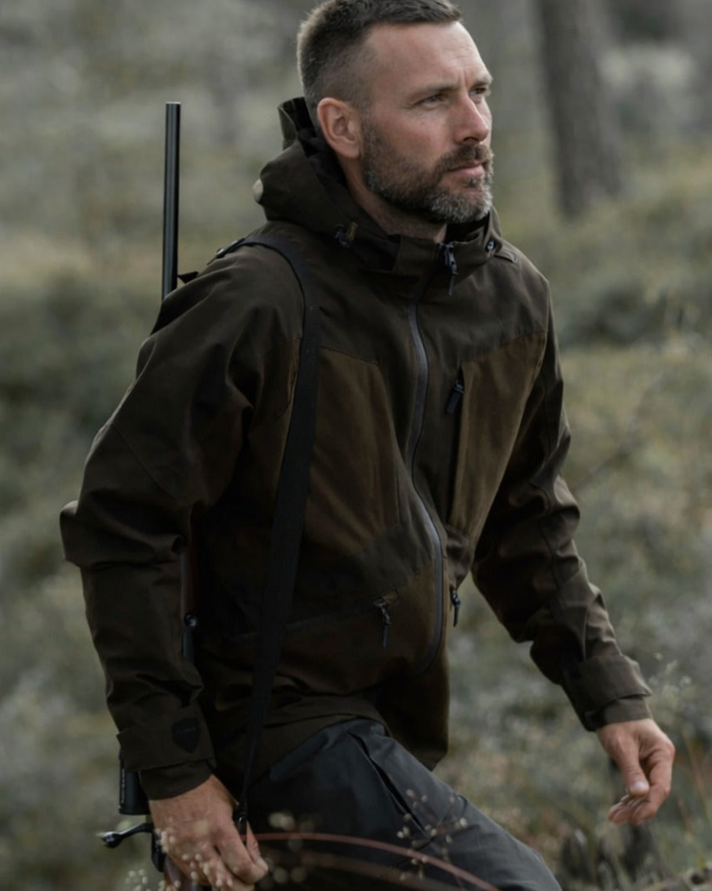 Green coloured Northern Hunting Mens Hakan Elk Waterproof Hunting Jacket on forest background 