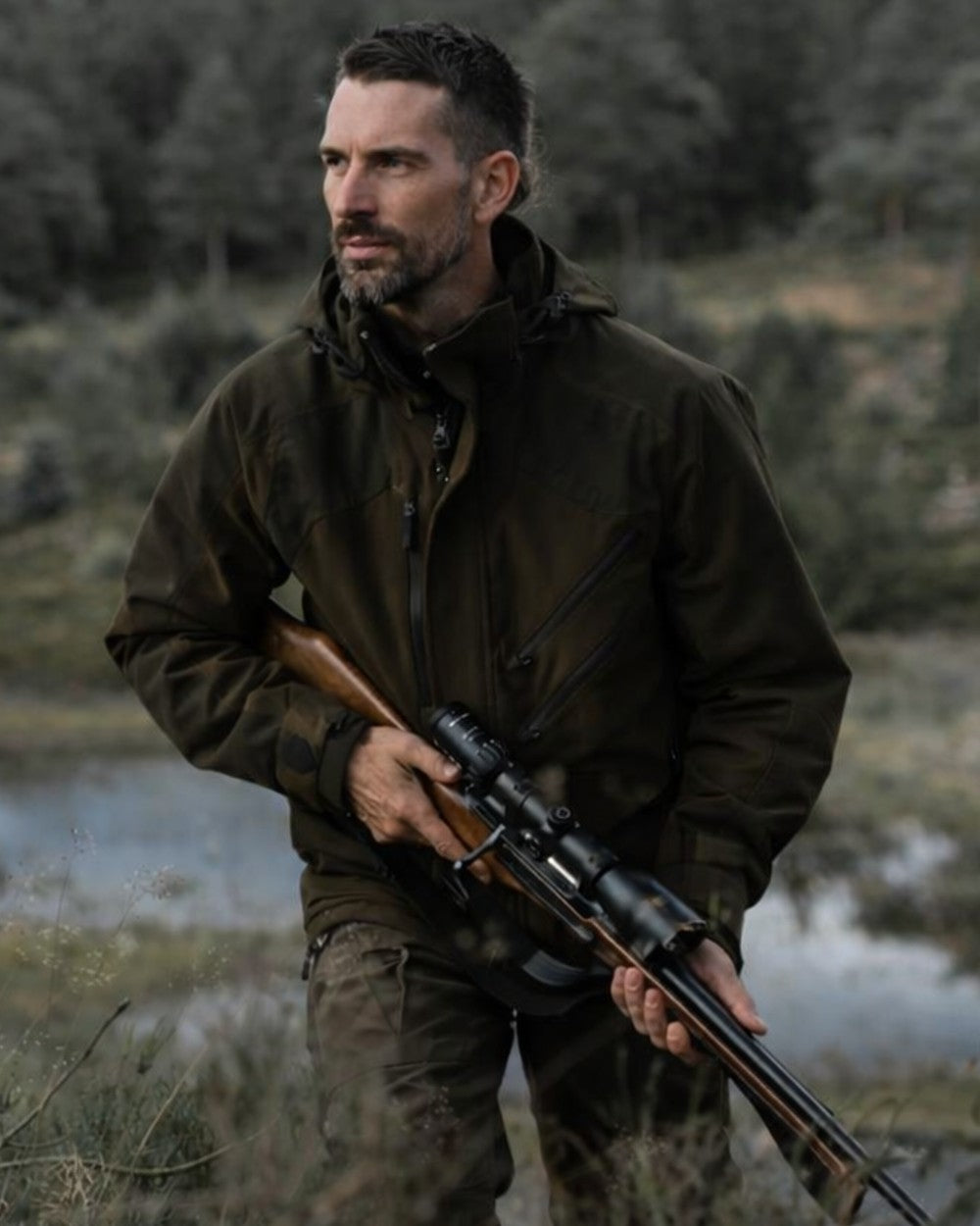 Green coloured Northern Hunting Mens Thor Ragnar G2 Waterproof Hunting Jacket on forest background 