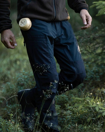Black coloured Northern Hunting Mens Trond Pro Outdoor Trousers on forest background 