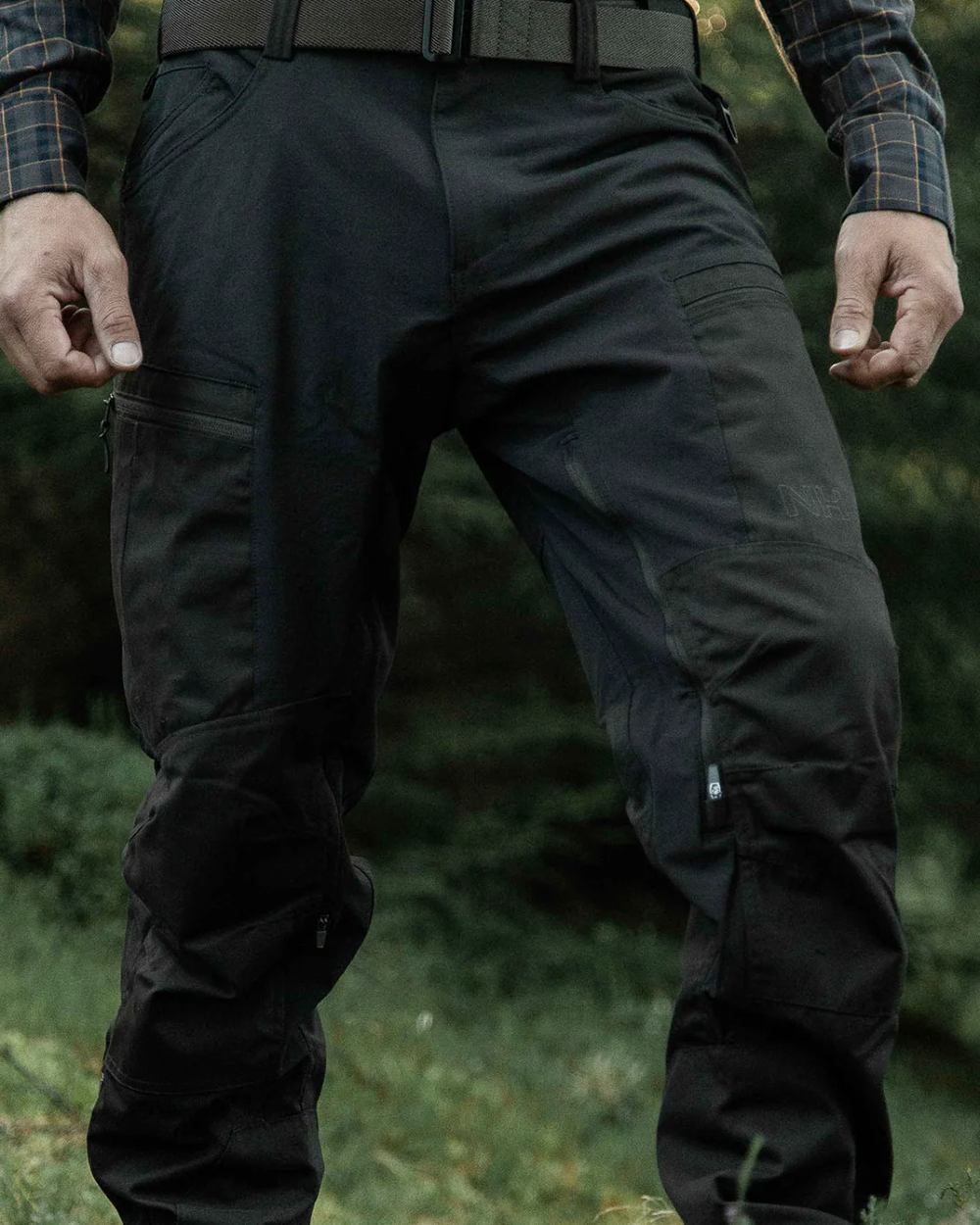Dark Green coloured Northern Hunting Mens Trond Pro Outdoor Trousers on forest background 