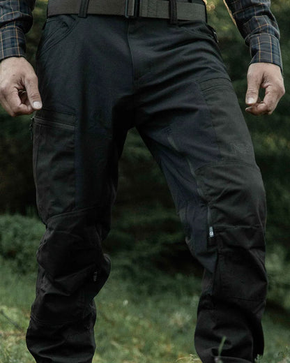 Dark Green coloured Northern Hunting Mens Trond Pro Outdoor Trousers on forest background 