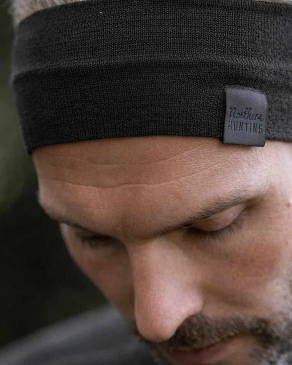 Dark Green coloured Northern Hunting Norr Rak Merino Headband on forest background 