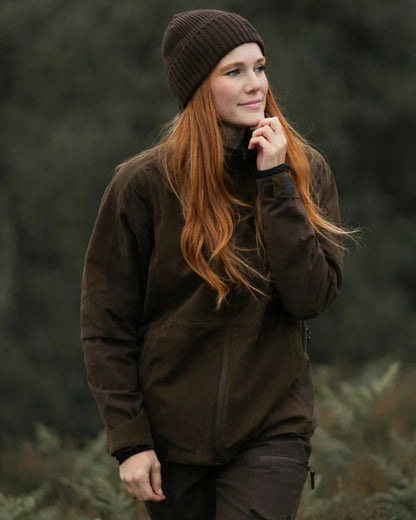 Dark Green coloured Northern Hunting Womens Alva Pil Waterproof Jacket on forest background 