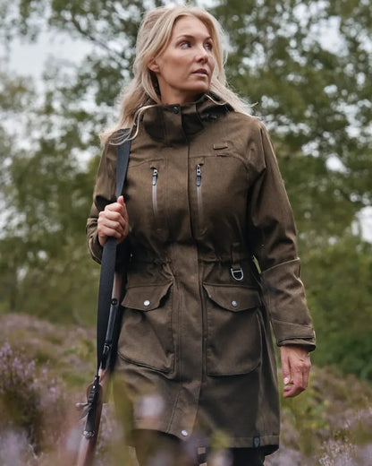 Green coloured Northern Hunting Womens Eira Sif Waterproof Hunting Jacket on forest background 