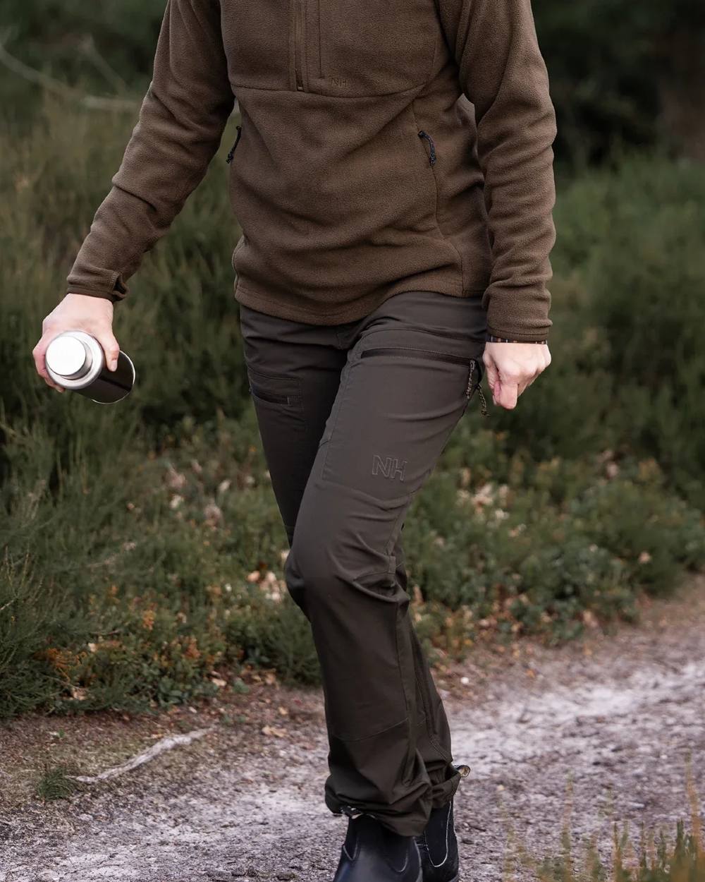 Dark Green coloured Northern Hunting Womens Eydis Light Tanatex Outdoor Trousers on forest background 